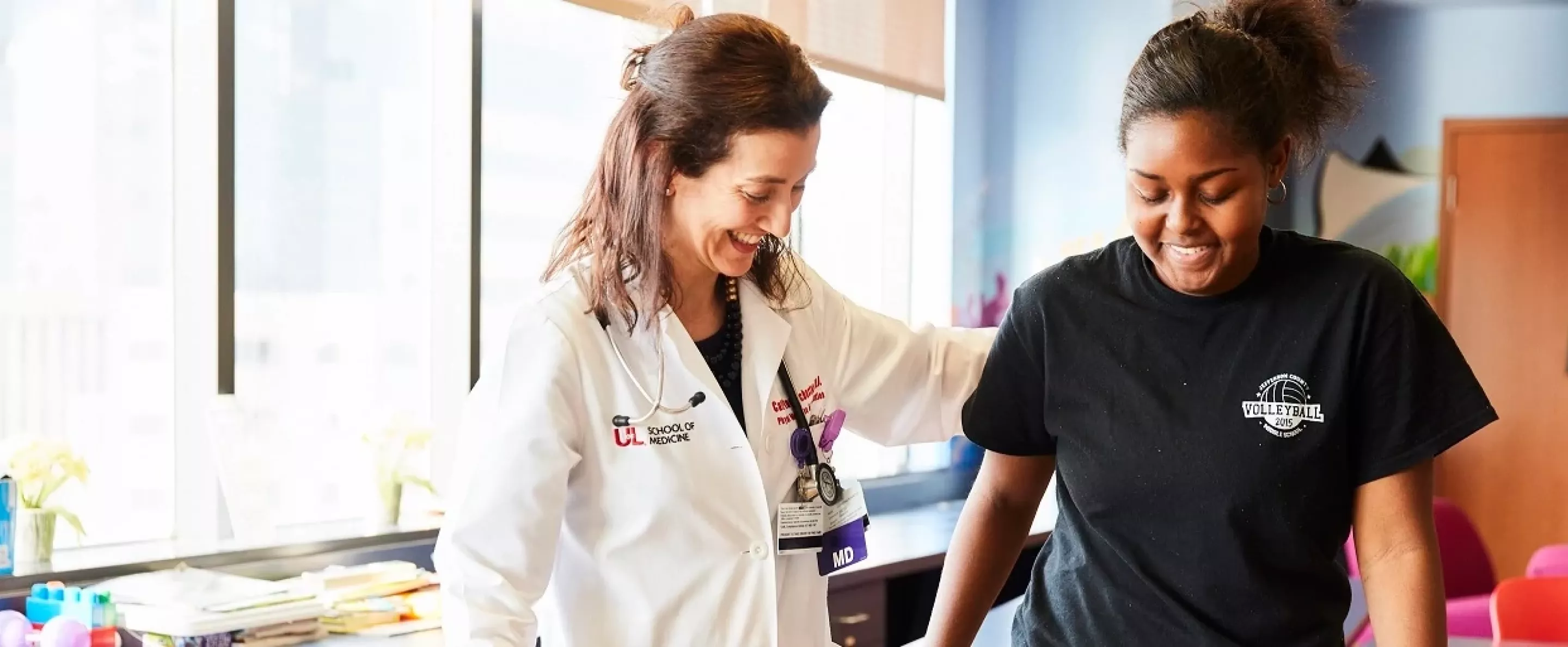 A physician assisting a patient while she walks.